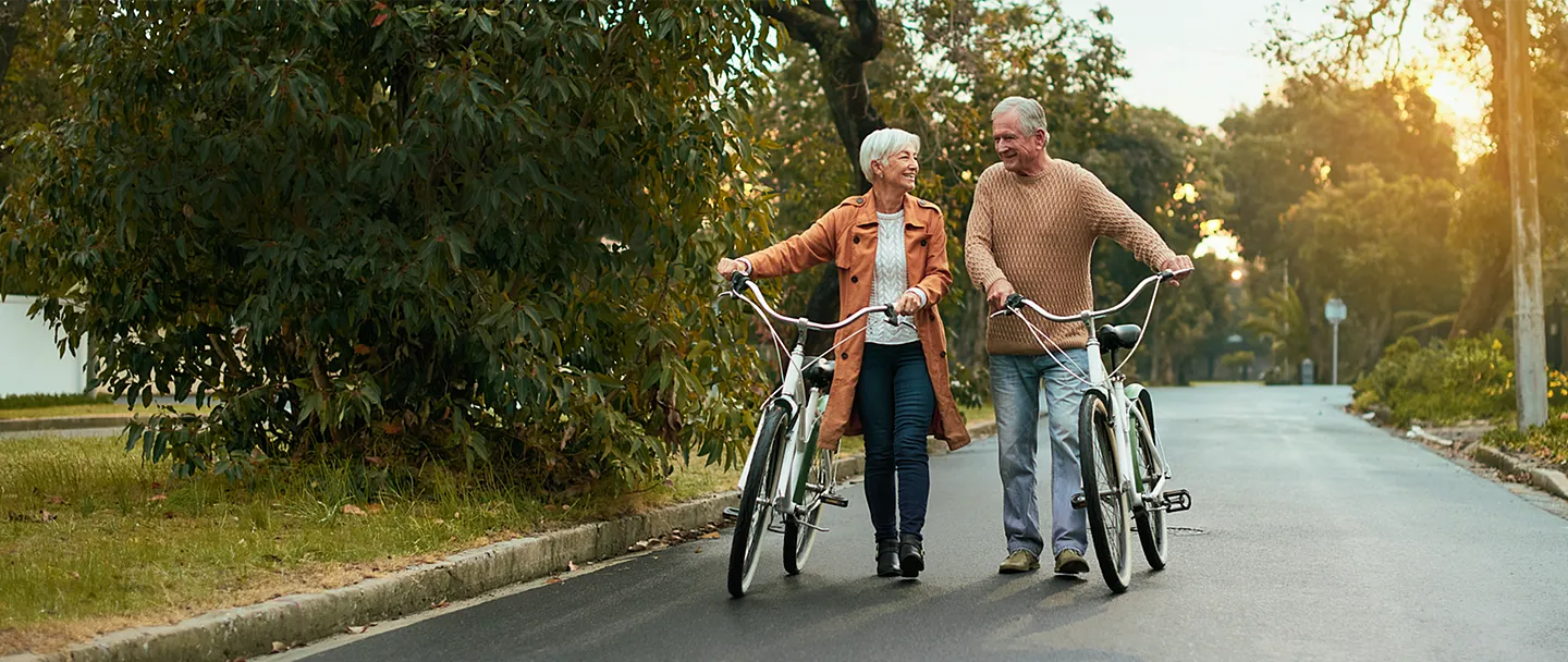 Aufnahme eines reifen Paares, das bei Sonnenuntergang eine Radtour unternimmt.